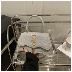 Détail du sac argenté avec rabat en strass et boucle dorée à pampilles lettre S