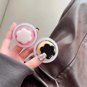 Detail of two floral MagSafe phone grips in pink and black with transparent casing