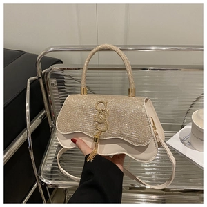 Détail du sac bandoulière crème avec strass argentés et accents métalliques dorés