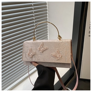 Detail of pink lace crossbody bag with 3D butterfly embroidery and gold metal handle