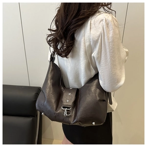 Detail view of brown vintage leather crossbody bag with silver star rivets and metal feet