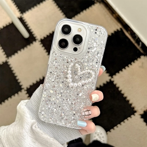 Close-up of glitter iPhone case featuring a pearl heart and rhinestone bow decoration