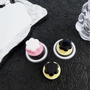 Detailed macro view of cream-style pudding phone grips on textured black background