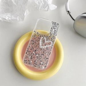 Sparkly iPhone case with silver glitter and pearl rhinestone heart on colorful ceramic tray