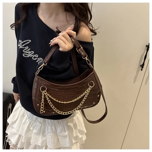 Detail of dark brown faux crocodile leather bag featuring vintage gold chain and crescent shape