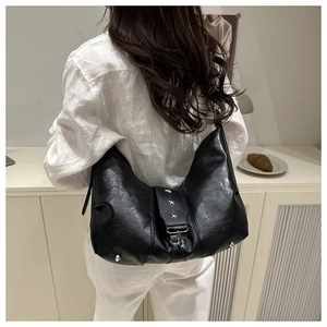 Detailed back view of model wearing a black moon bag with silver star rivets
