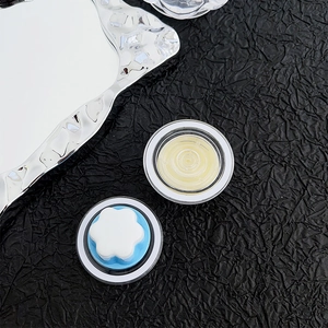 Close-up of magnetic phone grip featuring a white floral motif and cream blue base