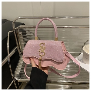 Détail du sac à main à paillettes roses avec boucle en S dorée et pampille décorative