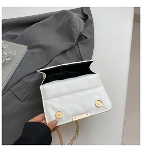 Detail view of the white quilted crossbody bag showing magnetic closure and interior