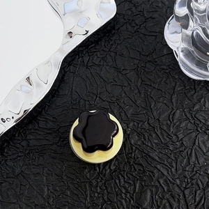 Detail of flower-shaped black magnetic phone socket on a textured aesthetic background