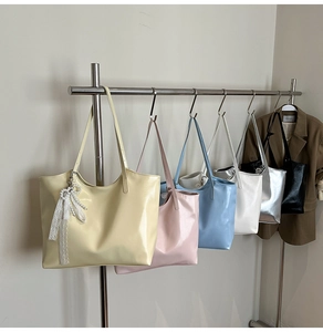 Close-up of glossy tote bags in diverse colors hanging on a minimalist metal display