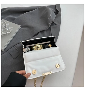 Detailed view showing the spacious interior and magnetic clasp of the white quilted bag