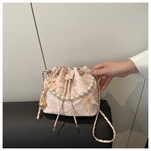 Detailed close-up of pink lace bucket bag with embroidery, 3D butterflies and pearl handle