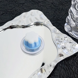 Detailed close-up of a silver liquid metal mirror tray with floral magsafe accessory