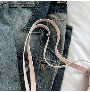 Dettaglio della tracolla in pelle rosa con cuciture fini e fibbia di regolazione argento