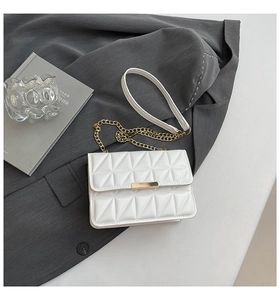 Detail of white quilted flap bag with gold metal clasp and premium chain strap
