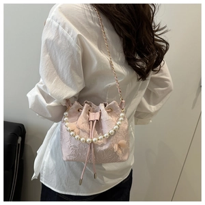 Detailed pink lace bucket bag with 3D butterfly accents and elegant pearl handle strap