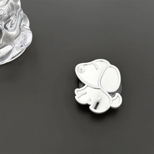 Detail of silver puppy phone grip with mirror finish and pearl nose on dark background