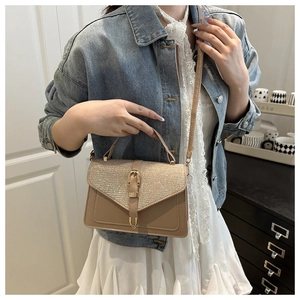 Detail of glitter flap texture and V-shaped metal buckle on beige leather crossbody bag