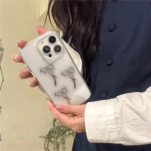 Λεπτομέρεια διαφανούς θήκης iPhone με τρεις ασημένιους τρισδιάστατους φιόγκους στο πίσω μέρος