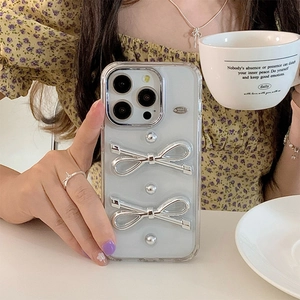 Dettaglio della custodia iPhone trasparente con fiocchi metallici argento in luce soffusa