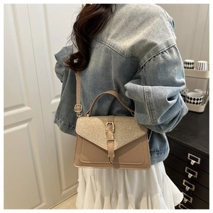 Detail of a chic square bag with glitter flap and adjustable strap on a model