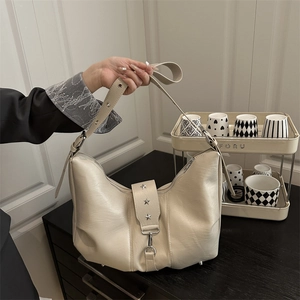 Chic cream white hobo crescent shoulder bag with star metal accents and buckle detail