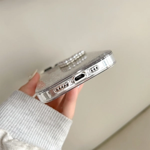 Detail of glitter iPhone case with pearls showing precise bottom cutouts and glossy finish