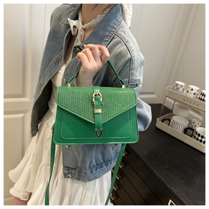 Detail of green leather crossbody bag with sequin flap and gold buckle on a model