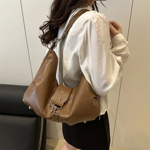 Brown leather hobo shoulder bag with silver star rivets shown on a model