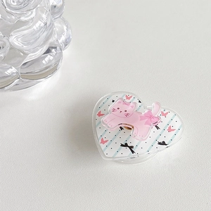 Detailed view of heart-shaped cat phone grip with bow patterns and clear acrylic base