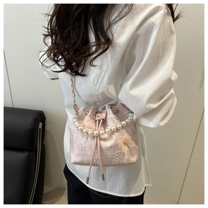 Detail of pink lace bucket bag with 3D floral embroidery and pearl handle strap