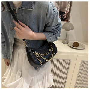 Détail du sac demi-lune noir motif crocodile avec triple chaîne en métal doré