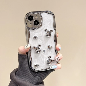 Close-up of a silver wavy iPhone case with 3D bear charms and sparkling glitter finish