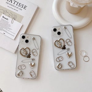 Transparent iPhone case with silver 3D heart, angel, and ring charms in Y2K style