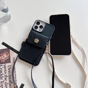 Detail of black quilted leather iPhone case with gold camellia snap and crossbody strap