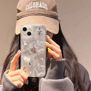 Detailed view of clear iPhone case featuring glittery silver stars and pearl heart charms