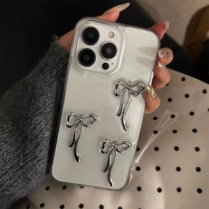 Detail of glitter iPhone case with three 3D silver metal bow ornaments held by hand