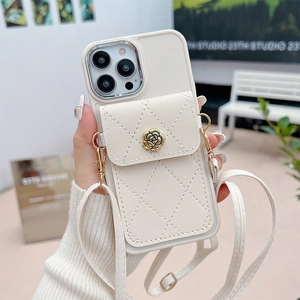 Detail of cream white leather iPhone case with gold flower clasp and crossbody strap