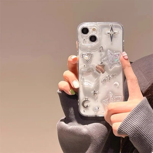 Handheld iPhone case with silver glitter stars, moon, and pearl heart charms on transparent cover