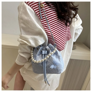 Detail of light blue lace bucket bag with 3D butterfly and pearl handle chain
