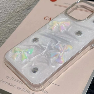 Close-up of iPhone case with 3D laser glitter bows and rhinestones on a soft background
