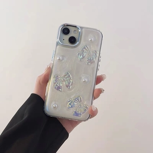 Detail of glitter iPhone case with 3D iridescent bows and pearl accents on clear silicone