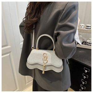 Λεπτομέρεια ασημένιας τσάντας γκλίτερ με χρυσό λογότυπο SSS και μεταλλικά φούντες