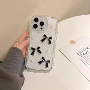 Detail of glitter iPhone case featuring 3D black bows and pearls with wavy transparent edges