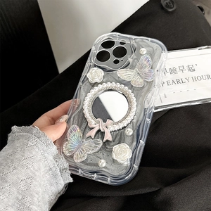 Gros plan d'une coque iPhone avec miroir, nœud perlé, papillons laser et roses en résine