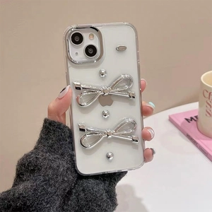 Dettaglio della custodia trasparente per iPhone con fiocchi 3D argento e perline metalliche