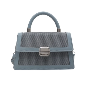 Chic light blue crossbody bag with mixed textures and silver metal buckle on white background