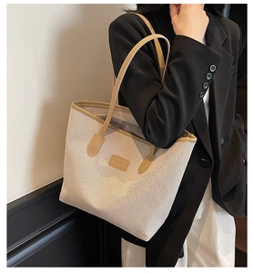 Close-up of contrast canvas tote bag showing interior lining and large capacity on model