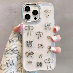 Dettaglio di fiocchi d'argento e glitter su custodia per iPhone tenuta in mano